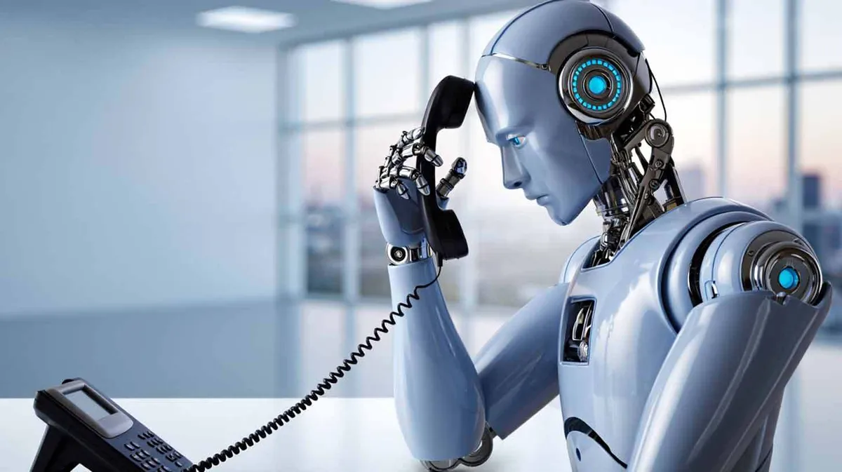Robot hoiab käes telefonitoru ja istub kontorikeskkonnas.